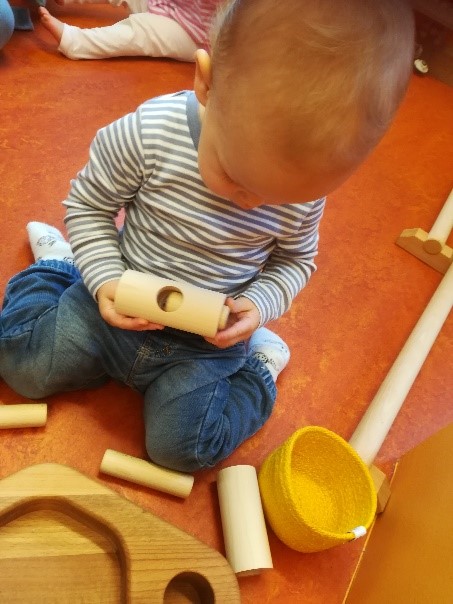  Mit Holzpielzeug spielendes Kleinkind 